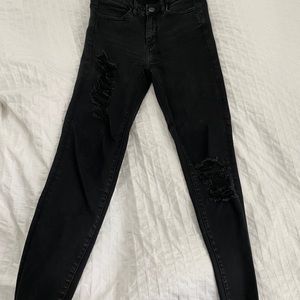 Black skinny jeans with rips at thigh